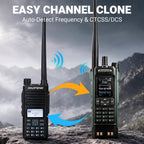 Two DAOPENG walkie-talkies Baofeng DM-1801 Pro displayed on a rock with a mountain background, featuring text that reads 'EASY CHANNEL CLONE' and 'Auto-Detect Frequency & CTCSS/DCS', with blue and orange signal arrows between them.
